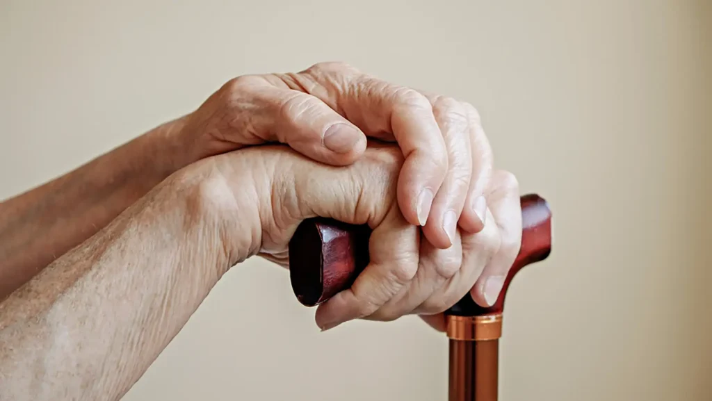 Compassionate Care: Older hands with a cane photo